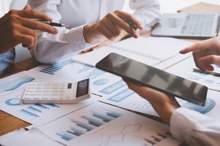 Foto: Personen besprechen Akten